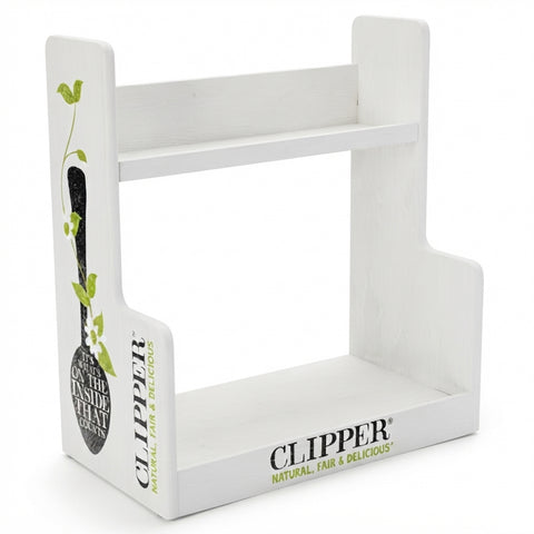 A white wooden display stand with two tiers, featuring printed branding for Clipper on the front and side panels with a decorative olive branch illustration.