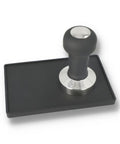 Coffee tamper with black rubber base and metal handle on a white background