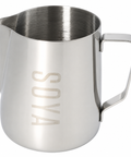 A stainless steel milk pitcher with a brushed finish, featuring a rectangular handle and the brand name 'SOYA' debossed vertically on the front, set against a plain white background.
