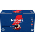 A blue box of Nescafe Original Decaf instant coffee, featuring a red and white logo, a graphic of a red mug filled with black coffee, and a side display of individual stick packs on a white background.