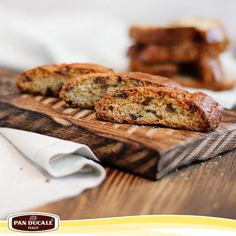 Biscotti on a wooden board with Pan Dècale logo at the bottom.