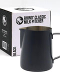 A black metal milk pitcher with a handle and pouring spout, shown in front of its white and black Rhino Classic Milk Pitcher box on a light gray background.